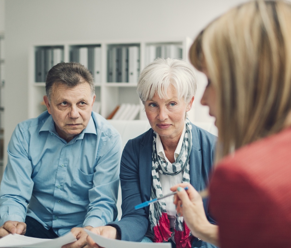 Mature Couple Meeting with Financial Advisor, selective focus to senior man and mature woman listening to financial advisor.